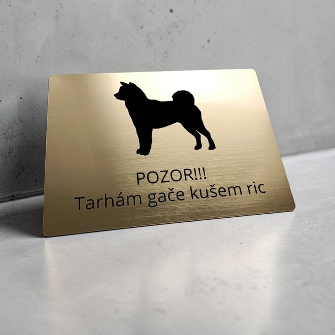 Zlatá tabulka se siluetou shiba inu a vtipným nářečním nápisem